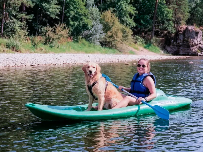 Una mujer baja plácidamente con su perro en una canoa K1