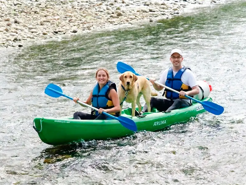 Pareja en una canoa con un perro en medio de la embarcación